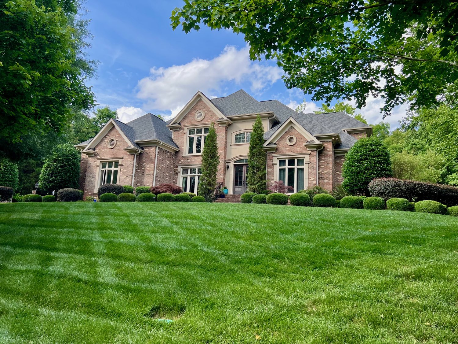 Brick French country estate on a terraced lawn