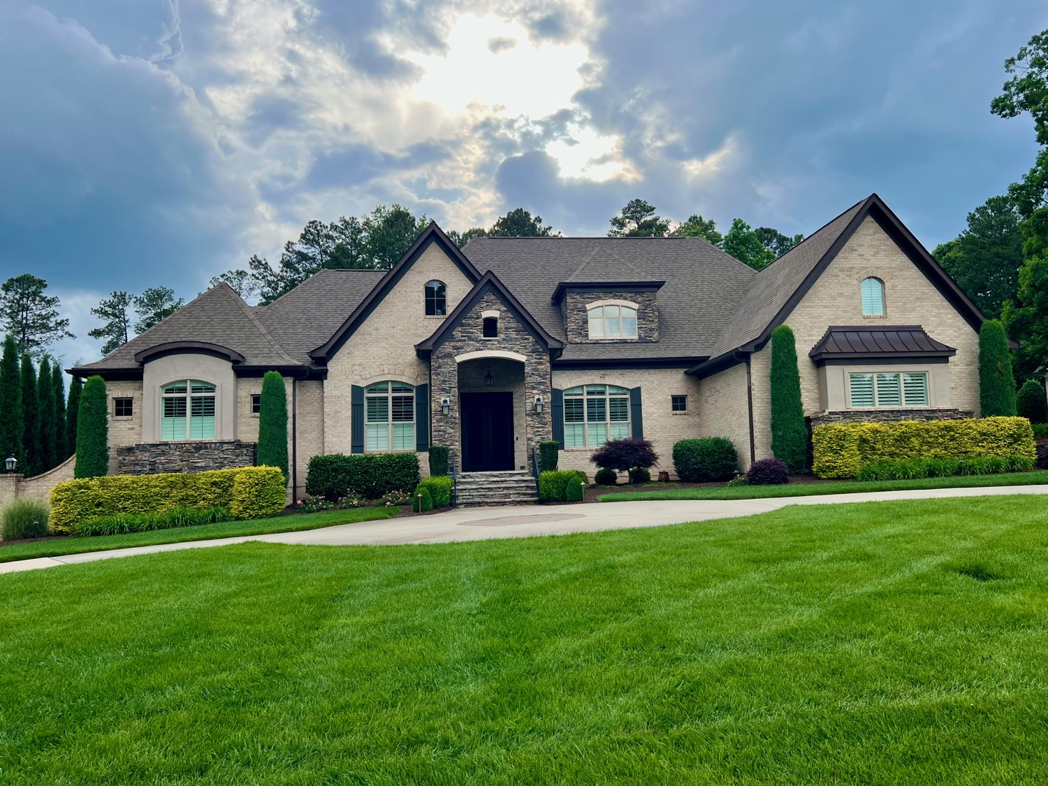 Stone and stucco French country home with steep gables